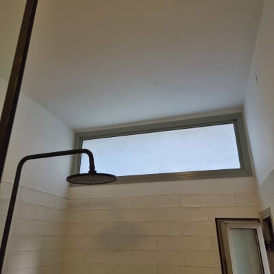 מקלחת עם ראש מקלחת וחלון עליון