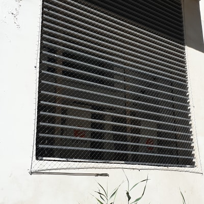 רשת מתכת על חלון למניעת כניסת יונים