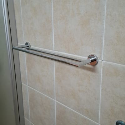 מתלה מגבות מתכת על קיר אריחים