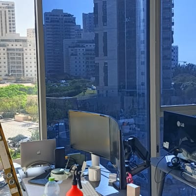 שולחן עבודה עם מחשבים, סולם וחלון גדול