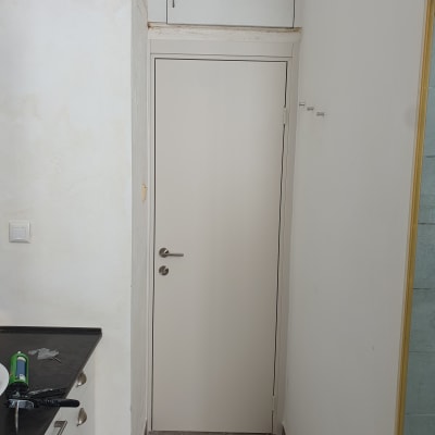 דלת לבנה עם ידית מתכת במטבח קטן