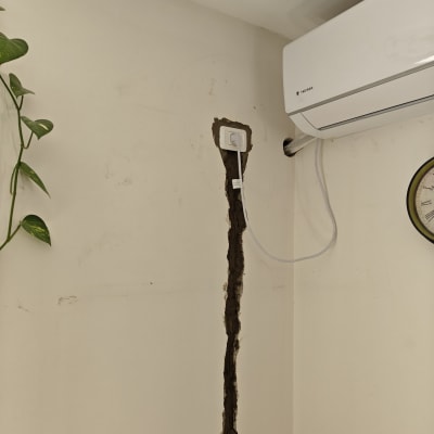 שקע חשמל מותקן בקיר עם חוט חשמל חשוף