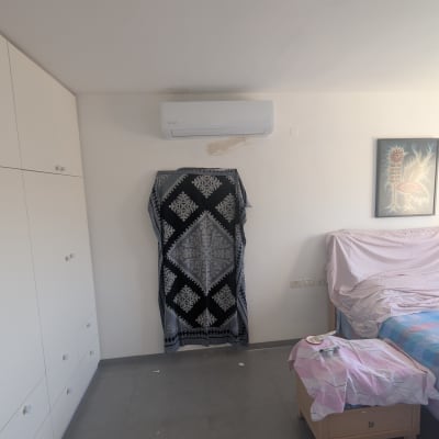 חדר עם מזגן מותקן על הקיר וארון בגדים