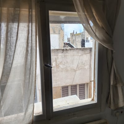 חלון זכוכית עם וילון פתוח חלקית