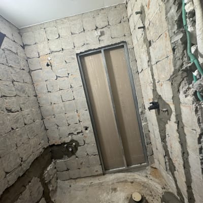 חדר בשיפוץ עם קירות חשופים וצנרת