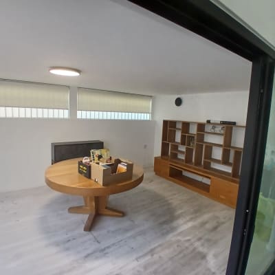 חדר עם שולחן עגול וארון מדפים מעץ