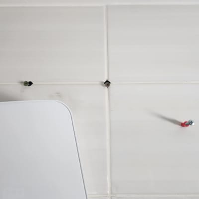 ברגים מותקנים על קיר אריחים לבן