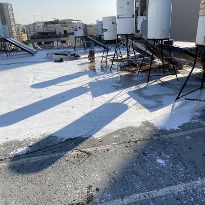 דודי שמש על גג עם צינורות וחיבורים חשמליים