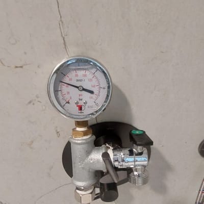 מד לחץ מים מחובר לצינור מתכת גמיש