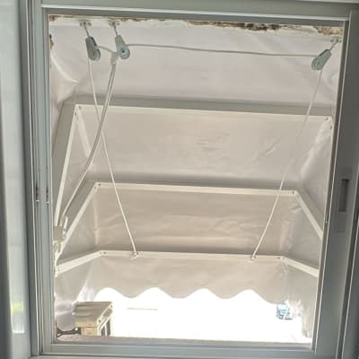 סוכך לבן עם מסגרת מתכת ומנגנון חבלים