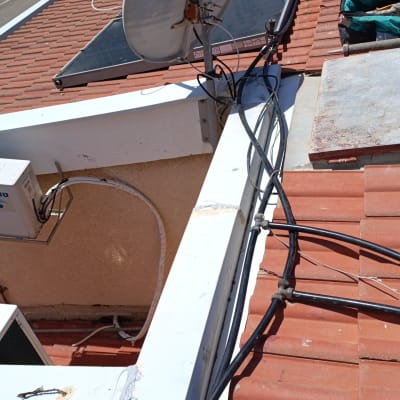 צלחת לוויין וכבלים על גג רעפים