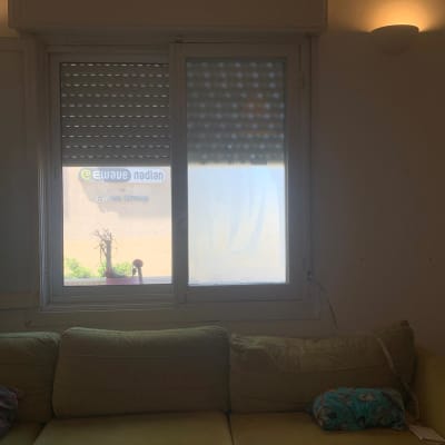 חלון זכוכית עם תריסים סגורים חלקית