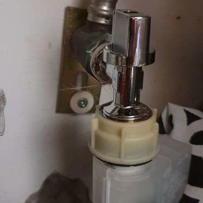 ברז מתכת מחובר לצינור פלסטיק מתחת לכיור