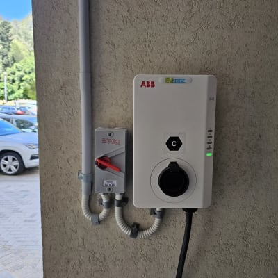 מטען חשמלי לרכב מותקן על קיר עם כבל מחובר