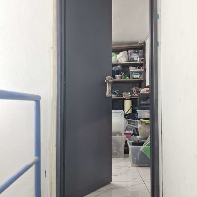 דלת אפורה פתוחה למחסן עם מדפים