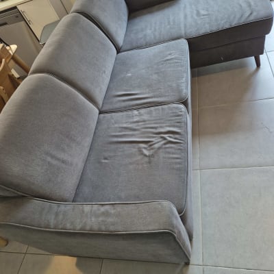 ספה אפורה עם כתמים על הריפוד