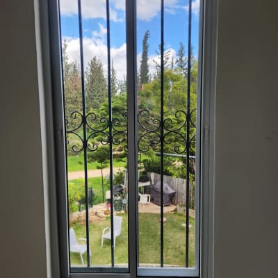 חלון אלומיניום עם סורגים נוף גינה