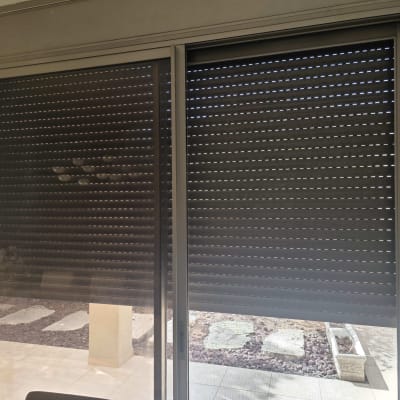 תריס גלילה מאלומיניום מורד בחלון הזזה גדול ליציאה לחצר