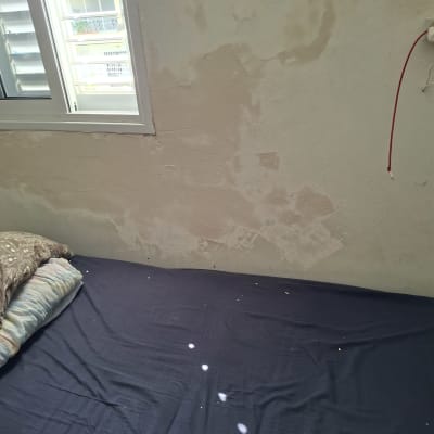 קיר עם סימני רטיבות ליד חלון