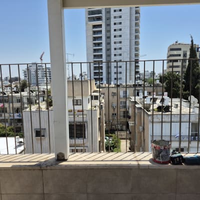 כלי עבודה על מעקה מרפסת עם נוף עירוני ברקע