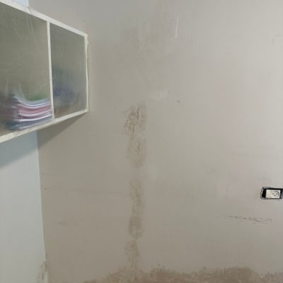 קיר עם סימני רטיבות וסדקים לפני צביעה