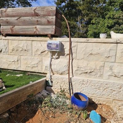 תיבת חשמל מותקנת על קיר אבן עם כבלים