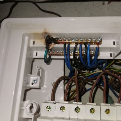 חוטים חשמליים מחוברים ללוח חשמל עם סימני שריפה