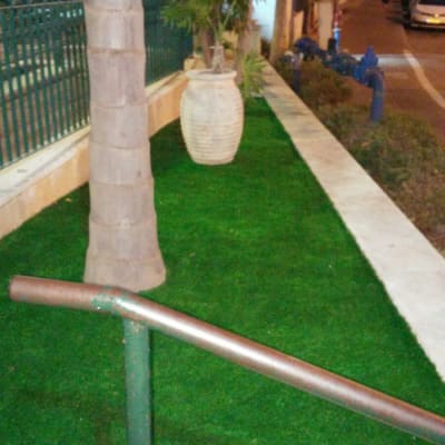 דשא סינתטי ועציץ גדול ליד עץ