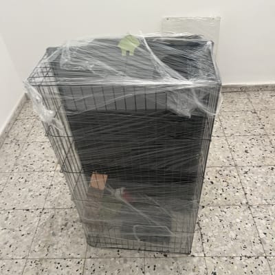 כלוב עטוף בניילון בחדר ריק עם רצפת אריחים