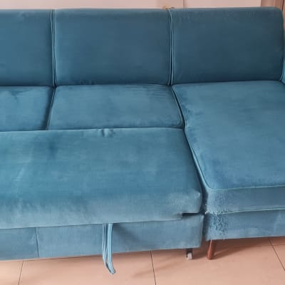 ספה כחולה בחדר עם רצפת קרמיקה