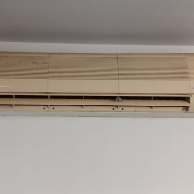 מזגן ישן מותקן על קיר לבן