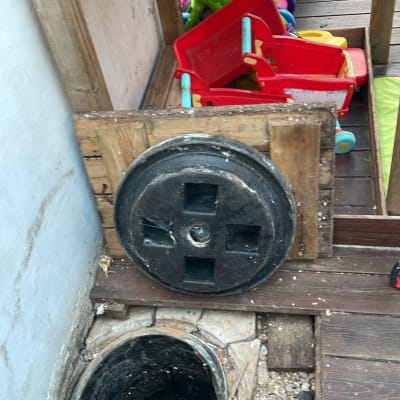 פתח ביוב פתוח עם מכסה מונח בצד