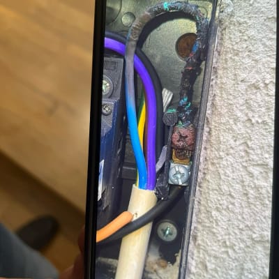 חוטי חשמל צבעוניים בתיבת חיבורים עם סימני שריפה