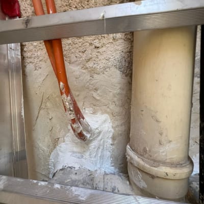 צינורות אטומים בחומר לבן על קיר