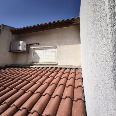 גג רעפים עם מזגן על קיר חיצוני