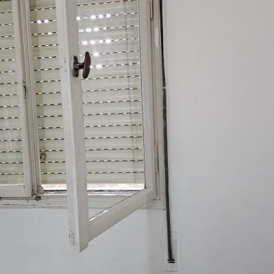 תריסים לבנים סגורים עם חלון פתוח לידם