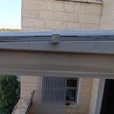 קורת מתכת אפורה מחוברת לקיר אבן