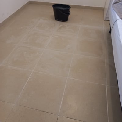 דלי שחור על רצפת אריחים מלוכלכת