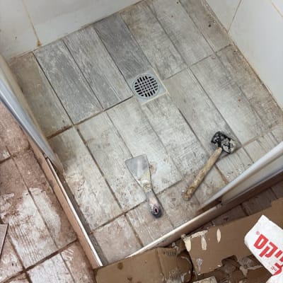 רצפת מקלחת עם כלים וחומרים לתיקון