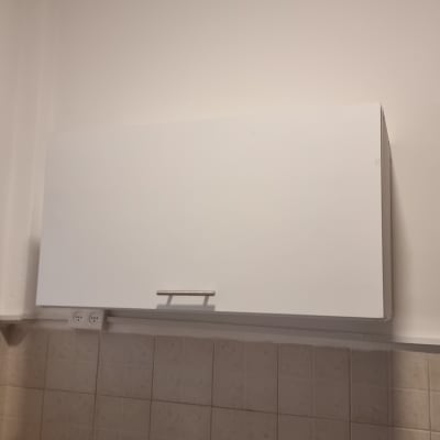 ארון מטבח לבן מעל כיור עם חומרי ניקוי