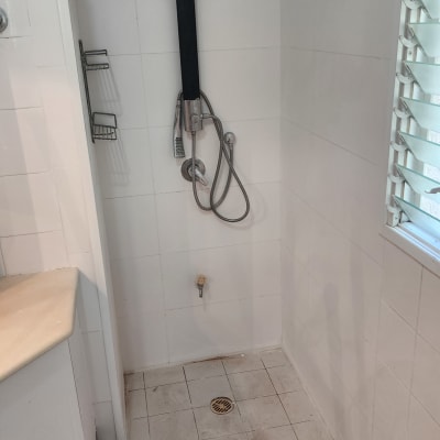 מקלחת עם אריחים לבנים, צינור ומקלחת יד