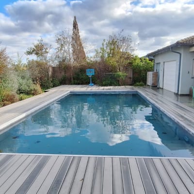 בריכת שחייה עם דק עץ וסביבה גינה ירוקה