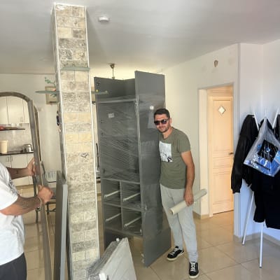 אדם עומד ליד ארון עטוף בניילון בבית