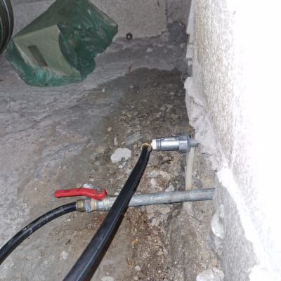 צינור שחור עם ברז אדום מחובר לקיר