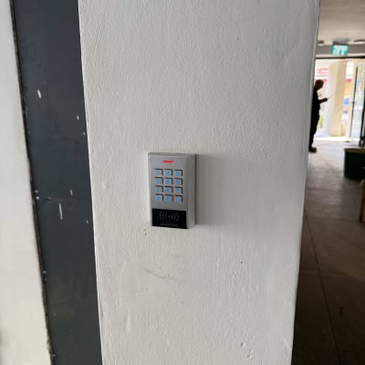 לוח מקשים עם תאורה כחולה על קיר לבן