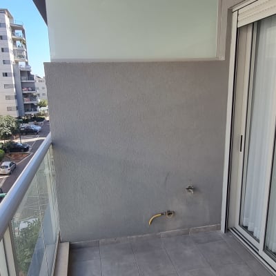 מעקה זכוכית במרפסת עם נוף עירוני