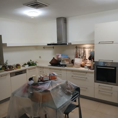 מטבח עם שולחן מכוסה בניילון, כלים וציוד צביעה