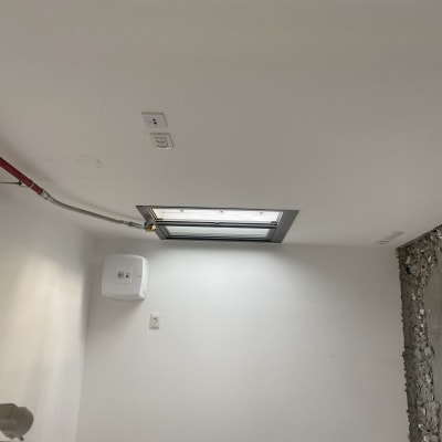 צינור כיבוי אש אדום מותקן על תקרה לבנה