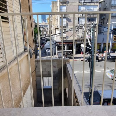 מעקה מתכת על מרפסת עם נוף לעיר