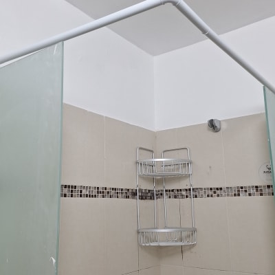 מקלחת עם מתלה מתכת על קיר אריחים